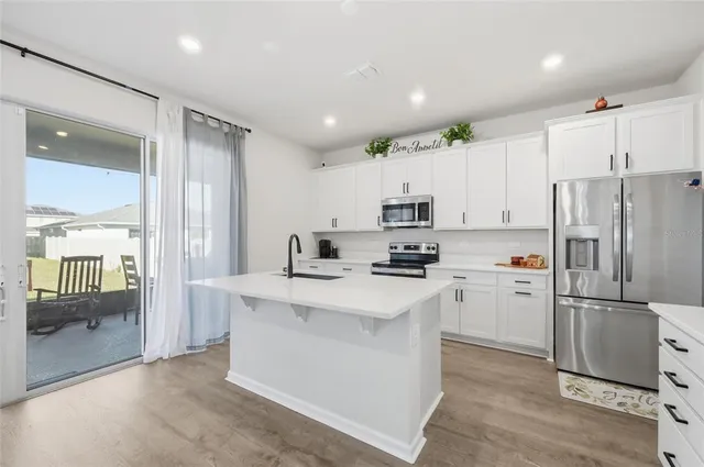 a kitchen with stainless steel appliances a refrigerator sink and microwave