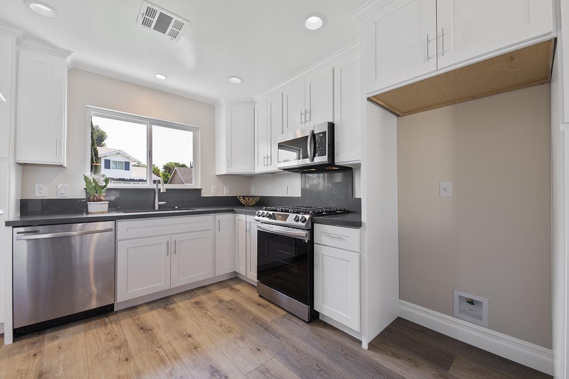 Cero Drive Santa Clarita, CA 91350 - Photo 34 of 45 a kitchen with stainless steel appliances granite countertop white cabinets a sink a stove a refrigerator and island with wooden floor