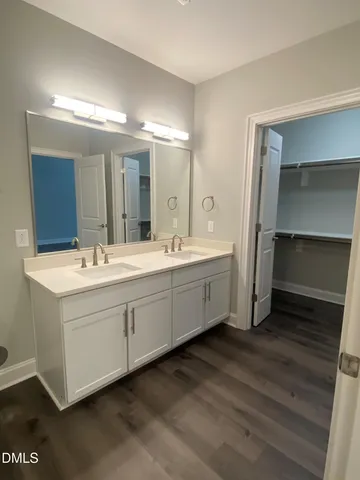 a spacious bathroom with a double vanity sink and mirror