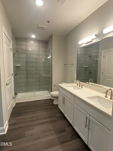 a bathroom with a double vanity sink toilet and shower