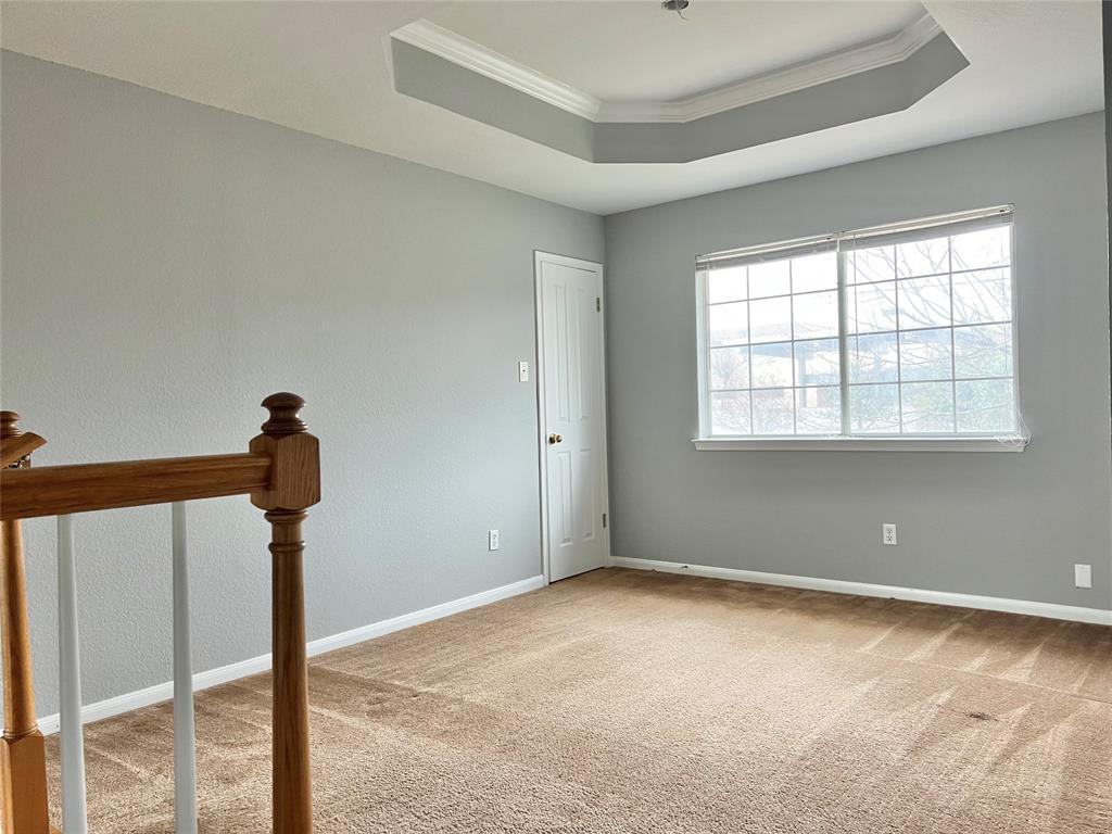 1809 Springwater Drive Round Rock, TX 78681 - Photo 10 of 25 Empty room with crown molding, a tray ceiling, and light colored carpet