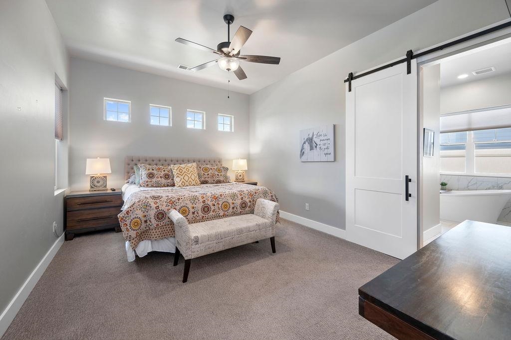 813 Red Apple Road Grand Junction, CO 81505 - Photo 21 of 30 a bedroom with a large bed and a chandelier