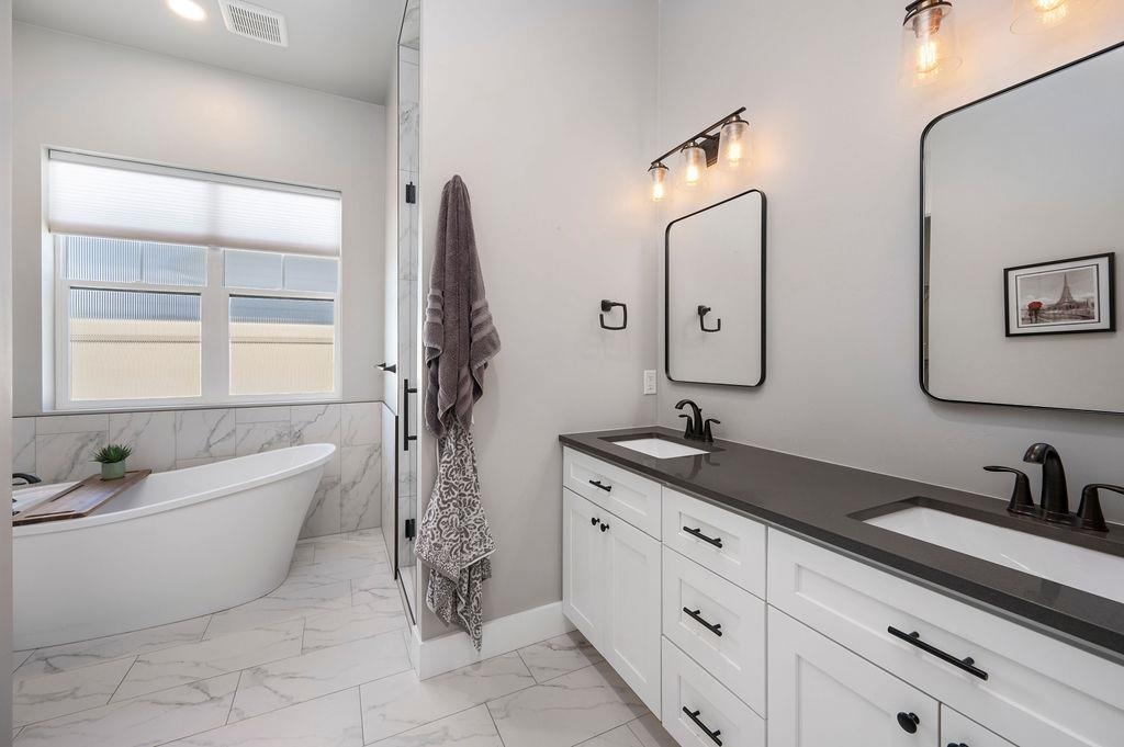813 Red Apple Road Grand Junction, CO 81505 - Photo 23 of 30 a spacious bathroom with a double vanity sink a mirror and a bathtub