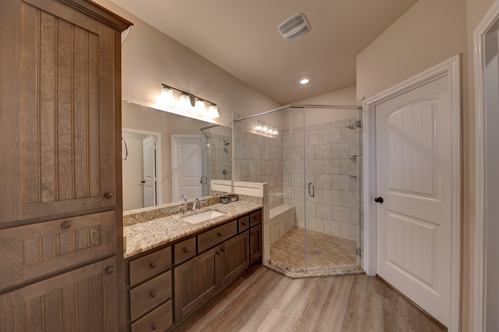 450 Jung Road Harper, TX 78631 - Photo 16 of 50 a bathroom with a granite countertop sink a mirror and a shower
