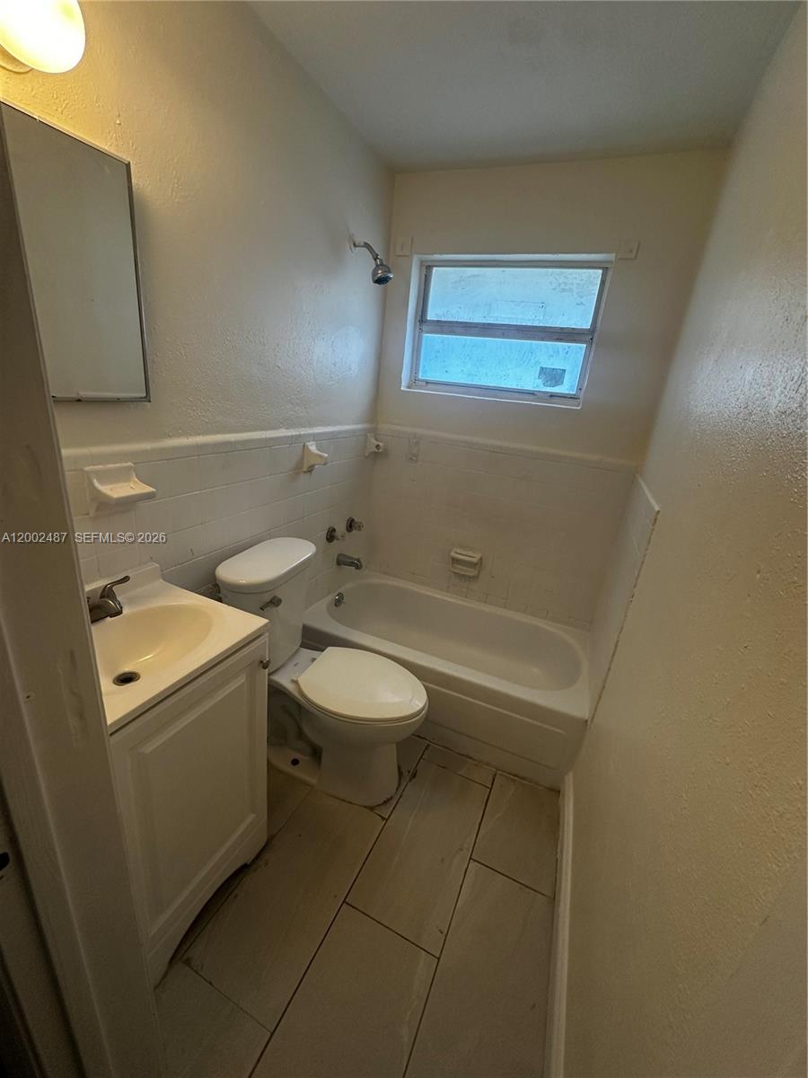 11862 Southwest 212th Street, Unit 11862 Miami, FL 33177 - Photo 13 of 24 a bathroom with a toilet a sink and mirror