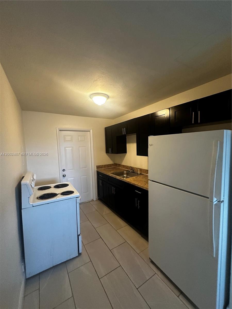 11862 Southwest 212th Street, Unit 11862 Miami, FL 33177 - Photo 19 of 24 a kitchen with granite countertop a refrigerator and a stove