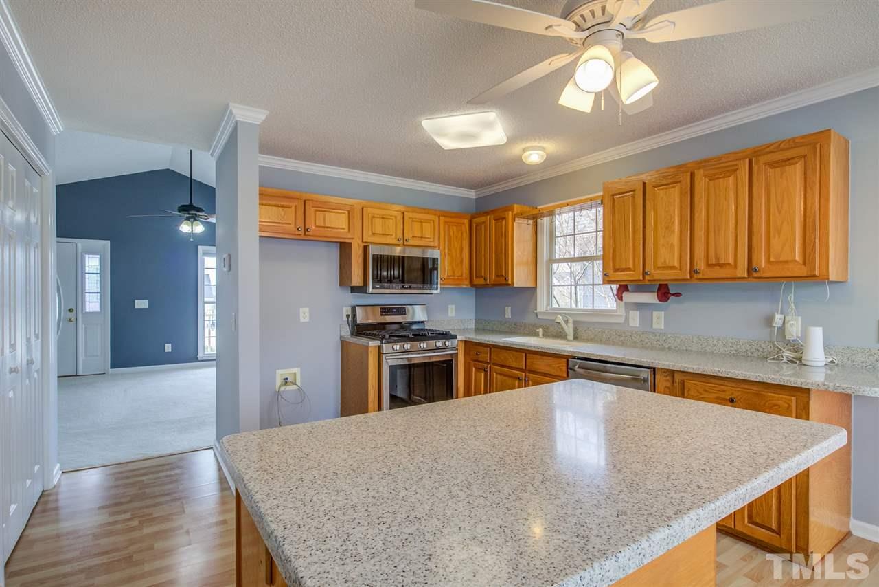1020 Transom Court Raleigh, NC 27603 - Photo 12 of 30 a kitchen with stainless steel appliances granite countertop wooden cabinets a stove and a sink