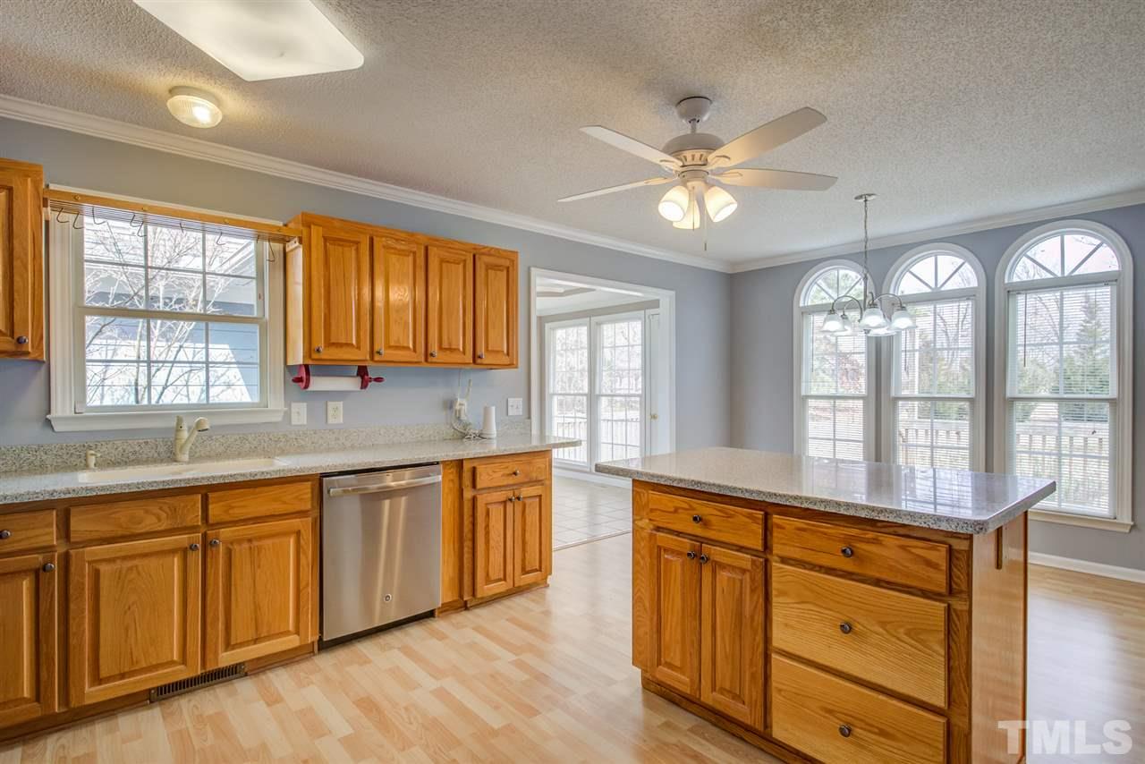 1020 Transom Court Raleigh, NC 27603 - Photo 10 of 30 a large kitchen with kitchen island granite countertop a large window and white cabinets