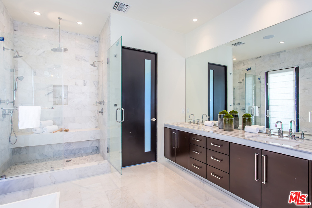 6533 Colgate Avenue Los Angeles, CA 90048 - Photo 16 of 19 a bathroom with a double vanity sink large mirror and shower
