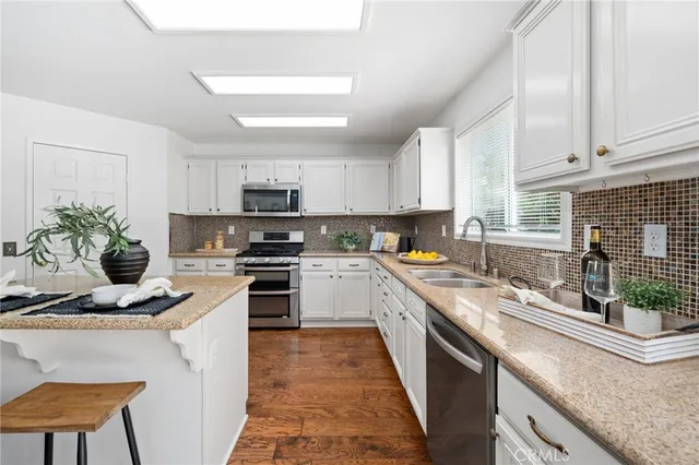 a kitchen with stainless steel appliances a stove refrigerator sink and cabinets