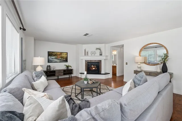 a kitchen with stainless steel appliances kitchen island granite countertop a dining table chairs and a refrigerator