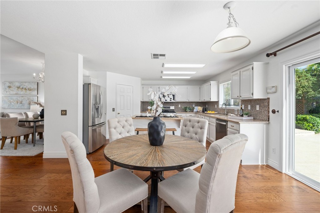 33751 Abbey Road Temecula, CA 92592 - Photo 16 of 41 a kitchen with stainless steel appliances kitchen island granite countertop a dining table chairs and a refrigerator