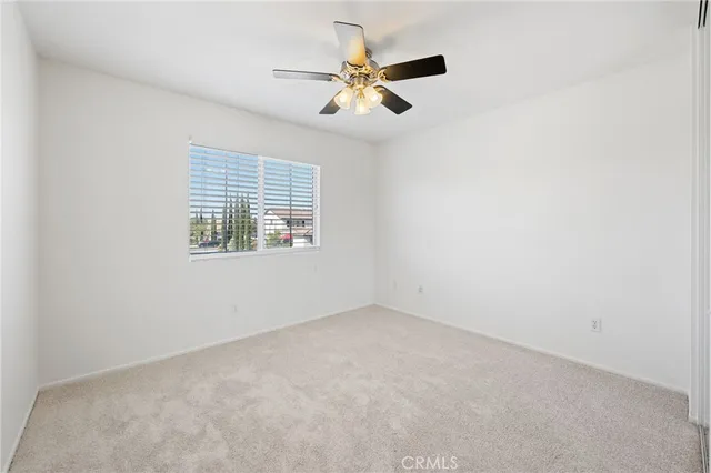 an empty room with closet and a chandelier fan