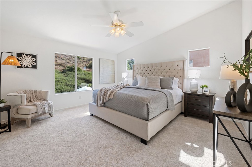 33751 Abbey Road Temecula, CA 92592 - Photo 26 of 41 a spacious bedroom with a bed a couch and a chandelier