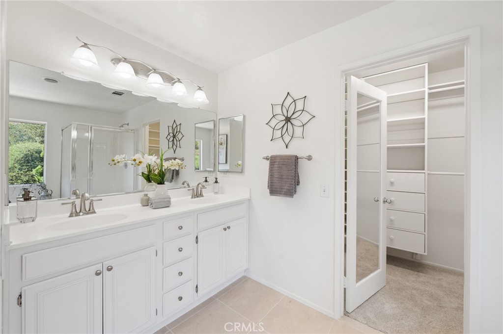33751 Abbey Road Temecula, CA 92592 - Photo 29 of 41 a bathroom with a double vanity sink a mirror a shower and a bathtub