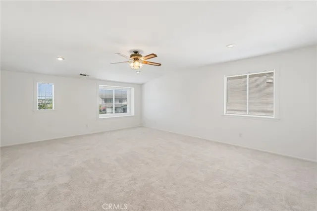 an empty room with window and ceiling fan