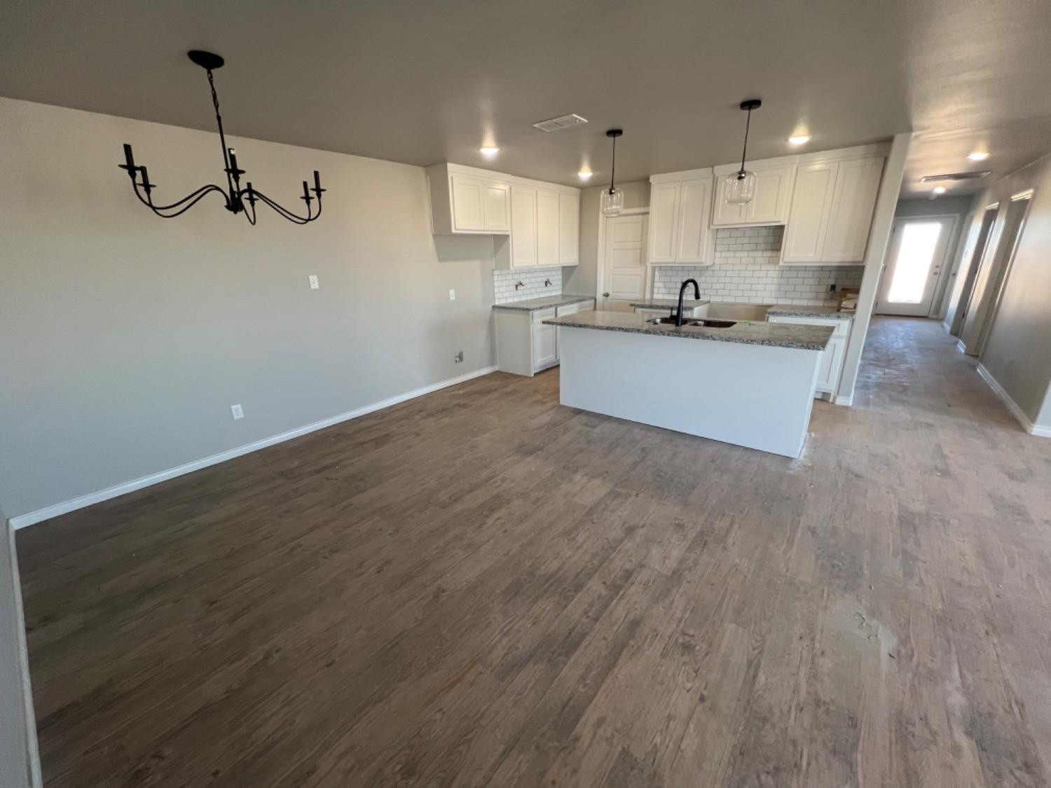 1407 17th Street, Unit AB Shallowater, TX 79363 - Photo 18 of 33 a view of a kitchen with a sink and wooden floor