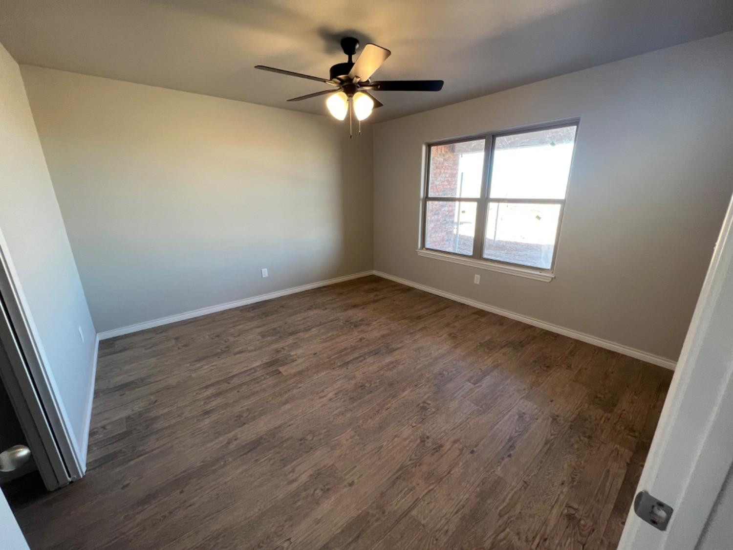 1407 17th Street, Unit AB Shallowater, TX 79363 - Photo 22 of 33 wooden floor in an empty room with a window