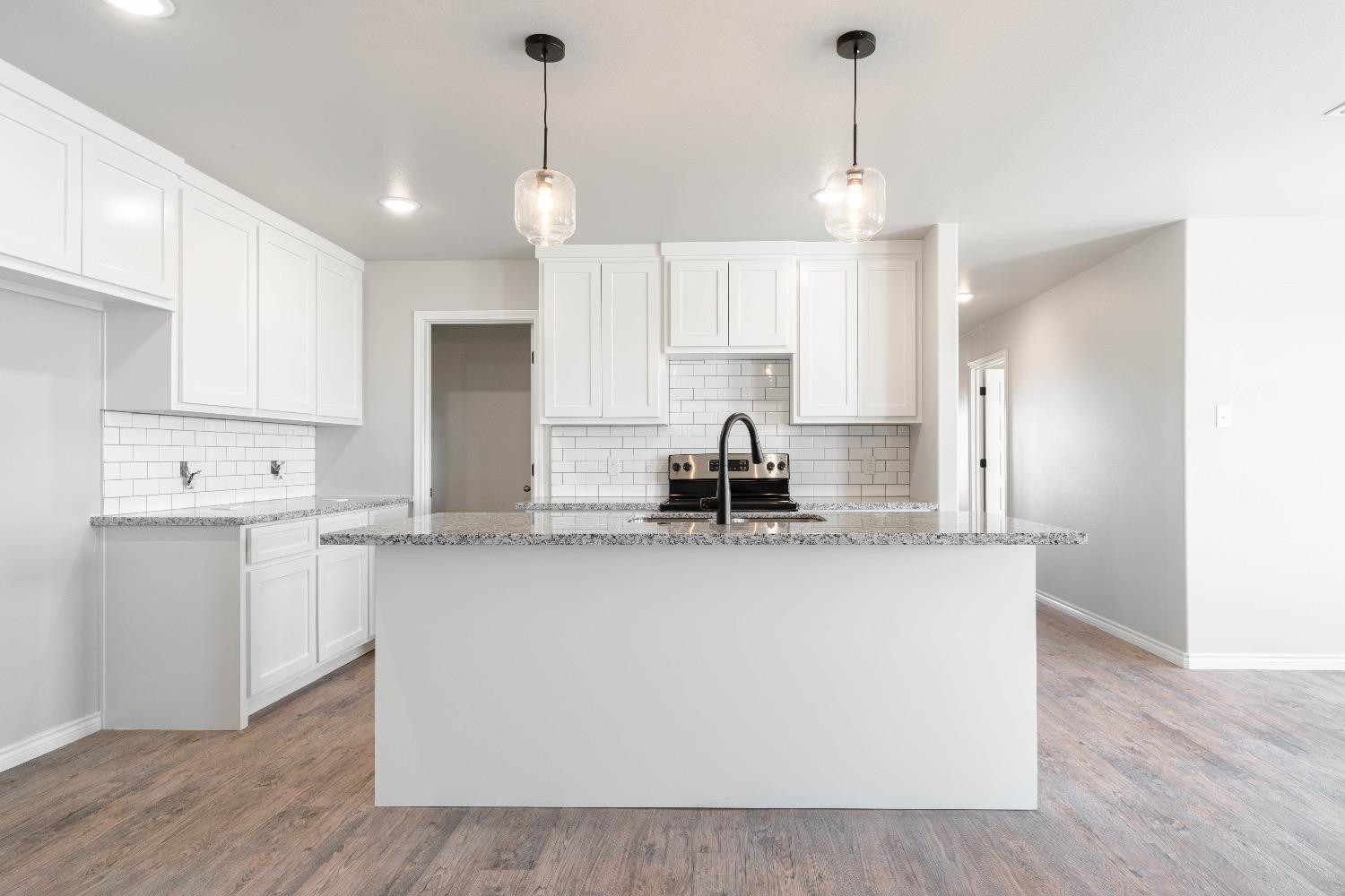 1407 17th Street, Unit AB Shallowater, TX 79363 - Photo 3 of 33 a kitchen with stainless steel appliances granite countertop a sink a stove a refrigerator and white cabinets