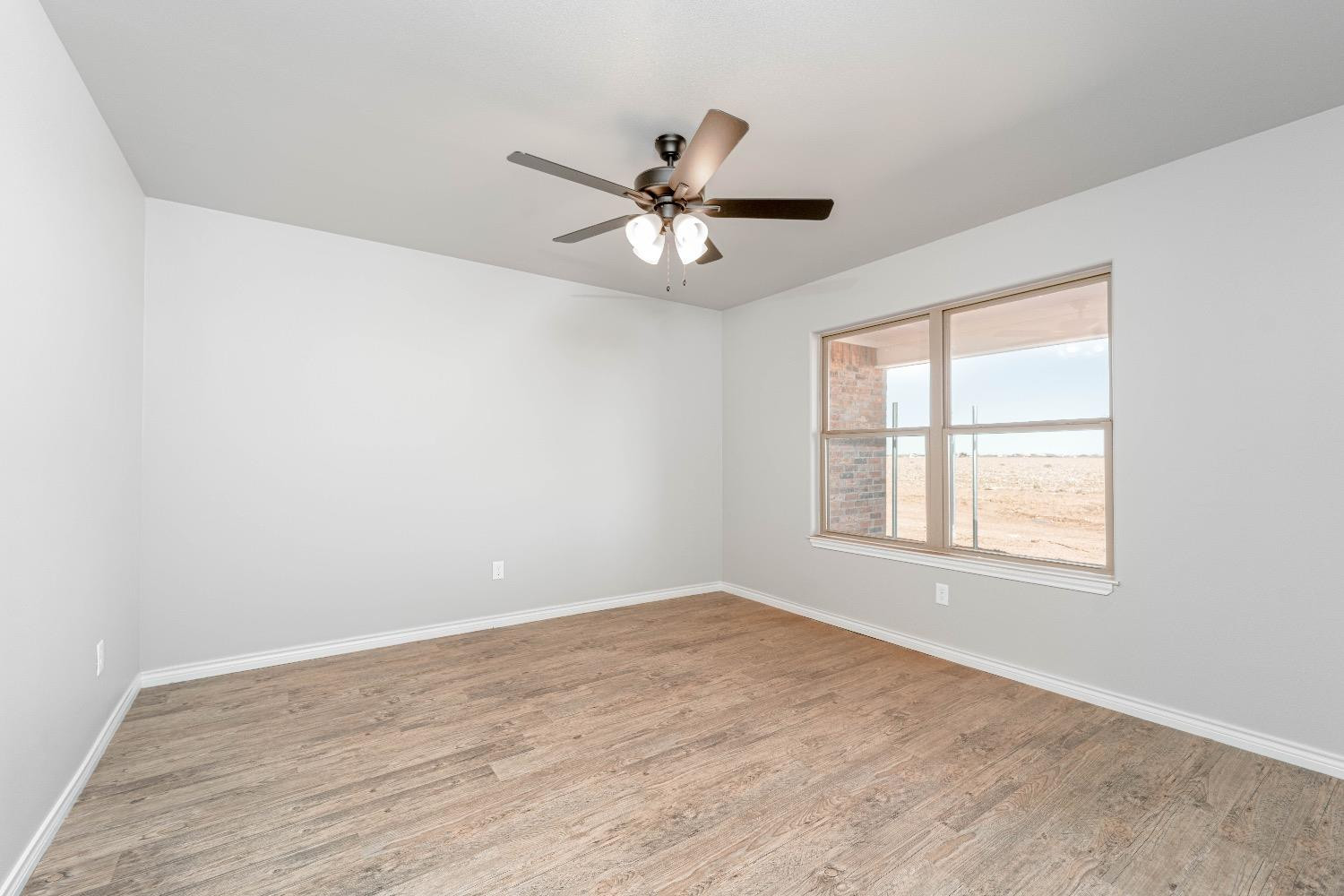 1407 17th Street, Unit AB Shallowater, TX 79363 - Photo 7 of 33 wooden floor in an empty room with a window