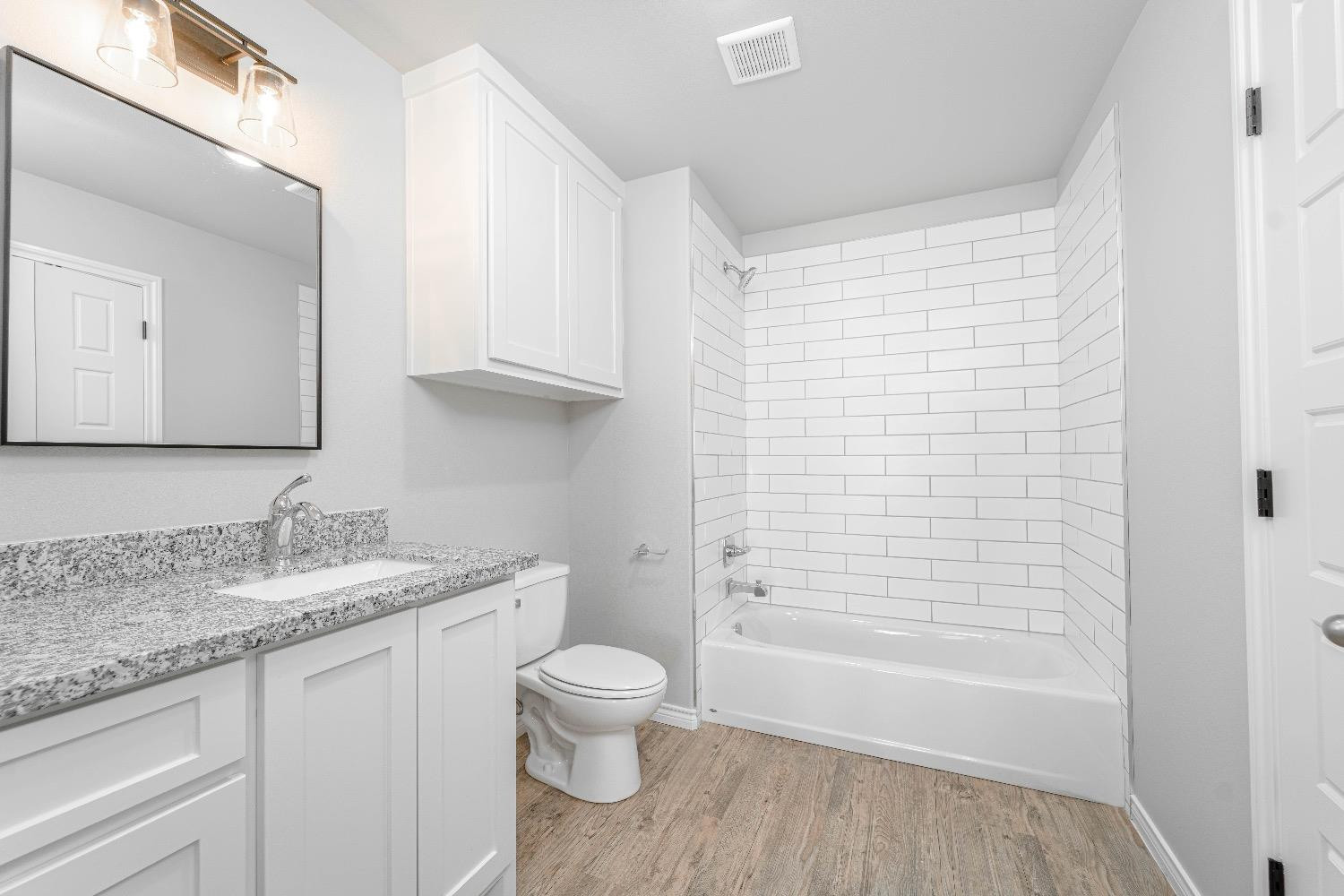 1407 17th Street, Unit AB Shallowater, TX 79363 - Photo 8 of 33 a bathroom with a granite countertop sink toilet and shower