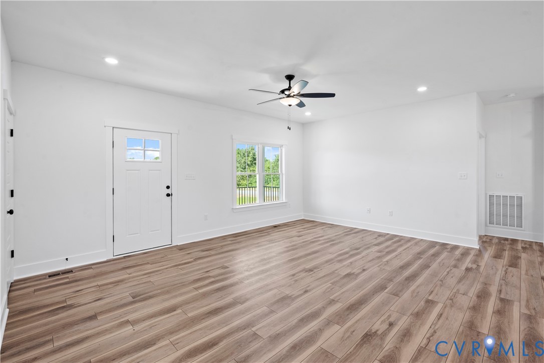 1841 Cartersville Road Goochland, VA 23063 - Photo 8 of 34 a view of an empty room with wooden floor and a ceiling fan