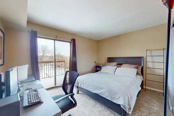 a bedroom with a bed and a large window