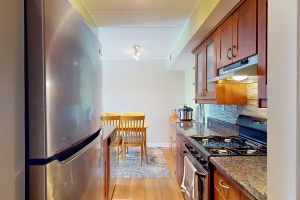 a kitchen with stainless steel appliances granite countertop a stove refrigerator sink and cabinets