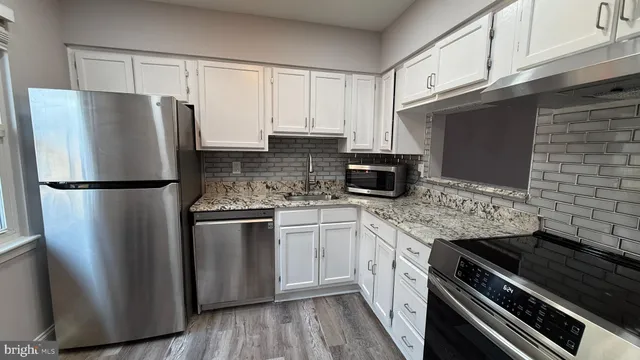 a kitchen with stainless steel appliances granite countertop a refrigerator and a stove