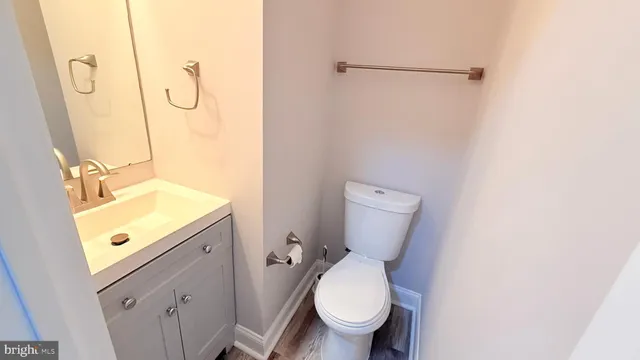 a bathroom with a granite countertop toilet sink and mirror