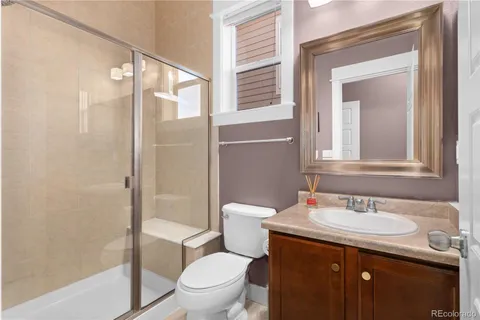 a bathroom with a granite countertop sink toilet and shower