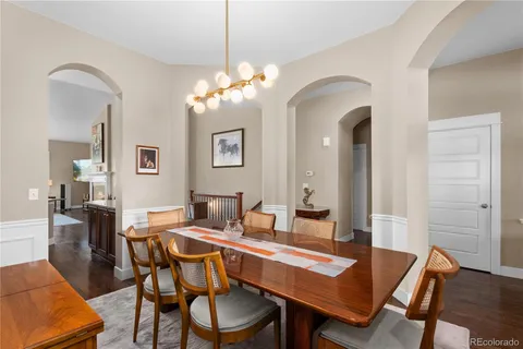 a view of a dining room with furniture a chandelier and wooden floor