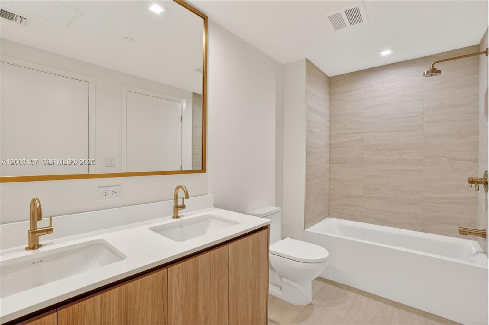 77 Southeast 5th Street, Unit 2705 Miami, FL 33131 - Photo 13 of 45 a bathroom with a granite countertop sink a toilet and a bathtub