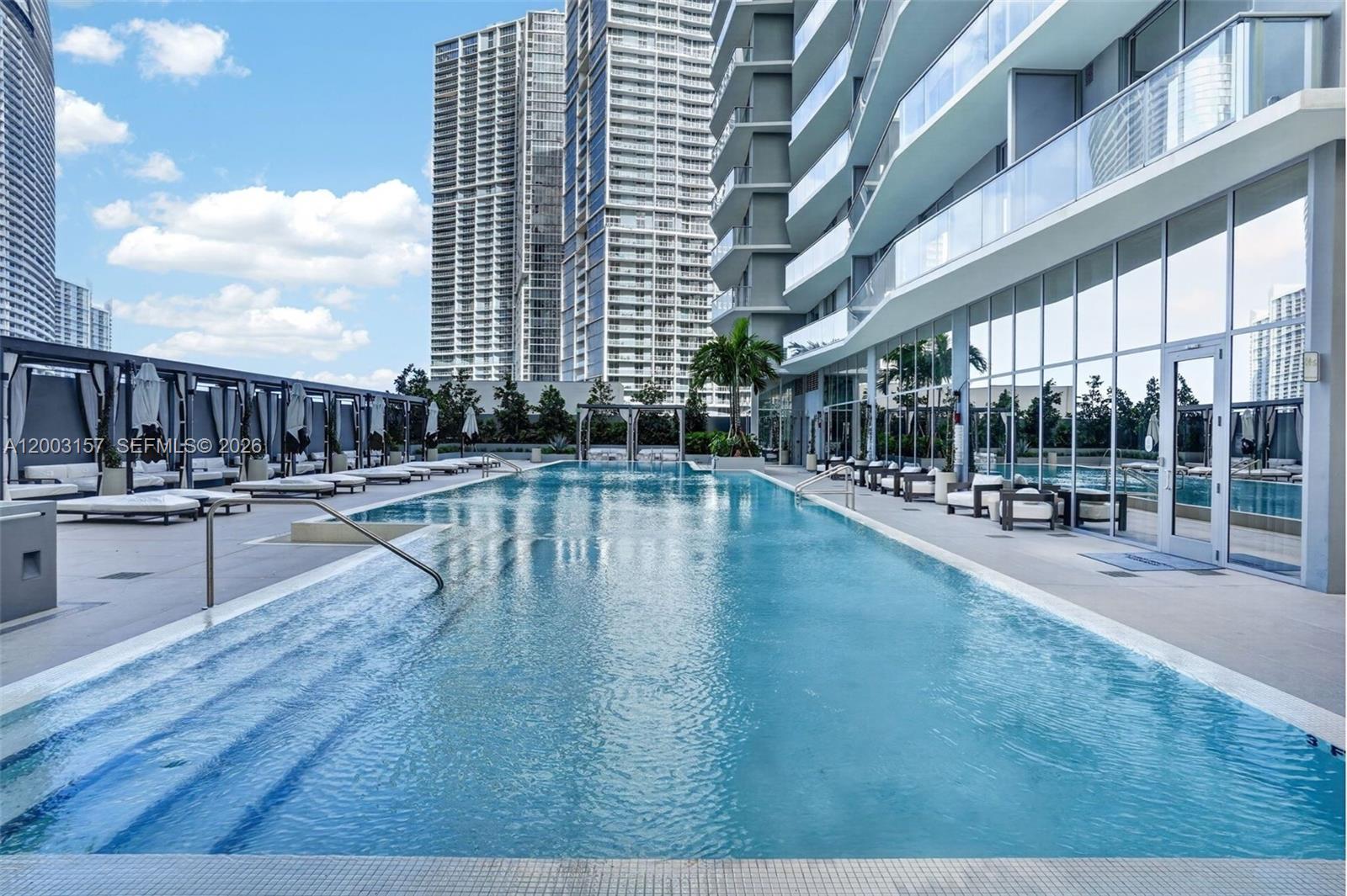 77 Southeast 5th Street, Unit 2705 Miami, FL 33131 - Photo 22 of 45 a swimming pool with outdoor seating and yard