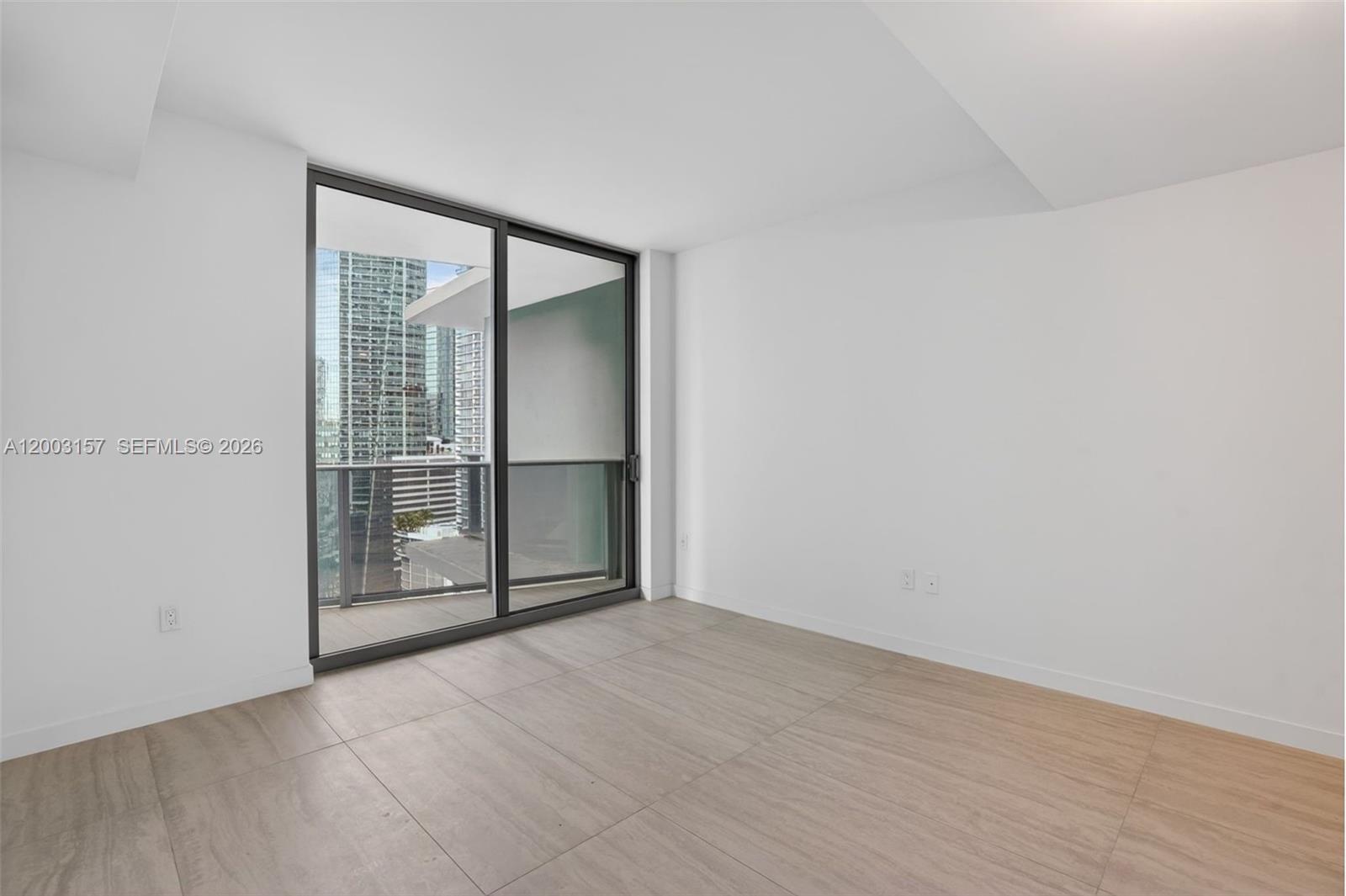 77 Southeast 5th Street, Unit 2705 Miami, FL 33131 - Photo 9 of 45 an empty room with sliding glass door