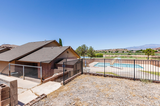 1470 Redwood Tree Street St. George, UT 84790 - Photo 53 of 53 Outdoor pool area featuring a perimeter fence and a water body in the background