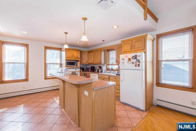551 Washington Street, Unit 2 Carlstadt, NJ 07072 - Photo 6 of 19 a kitchen with stainless steel appliances granite countertop a refrigerator a sink dishwasher a stove and a dining table with wooden floor