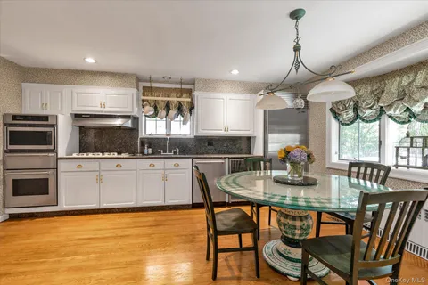 a kitchen with stainless steel appliances kitchen island granite countertop a kitchen island hardwood floor and a sink