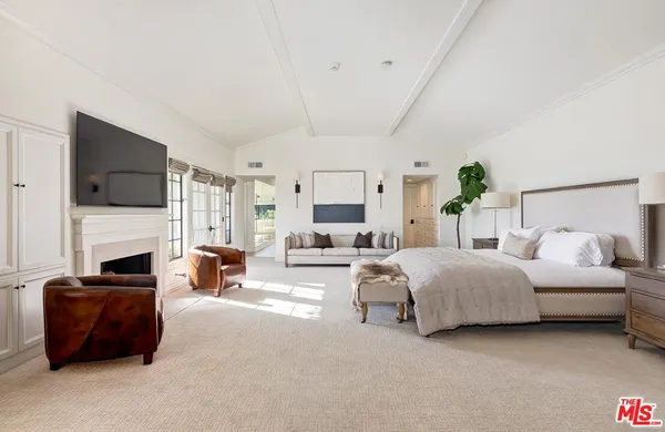 a spacious bedroom with a bed and a fireplace