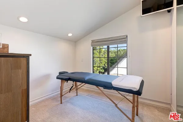 a view of a workspace with furniture and a window