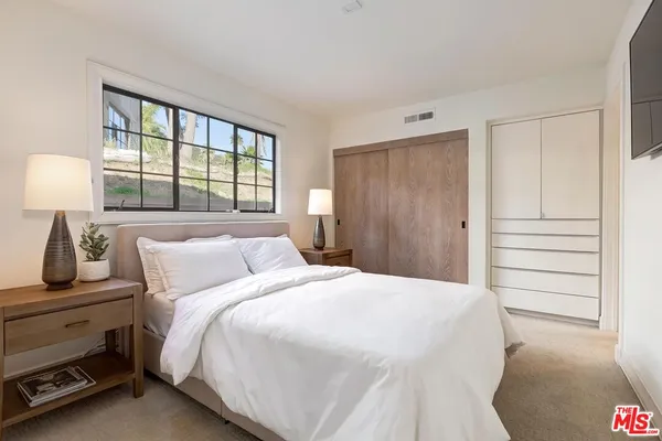 a bedroom with a bed and a window