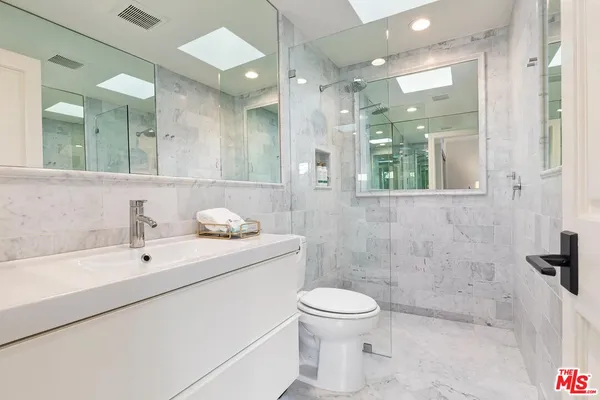a bathroom with a toilet sink and mirror