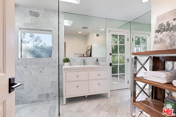 a bathroom with a double vanity sink a mirror and shower