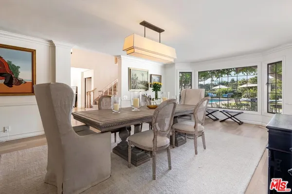 a dining room with furniture and a floor to ceiling window