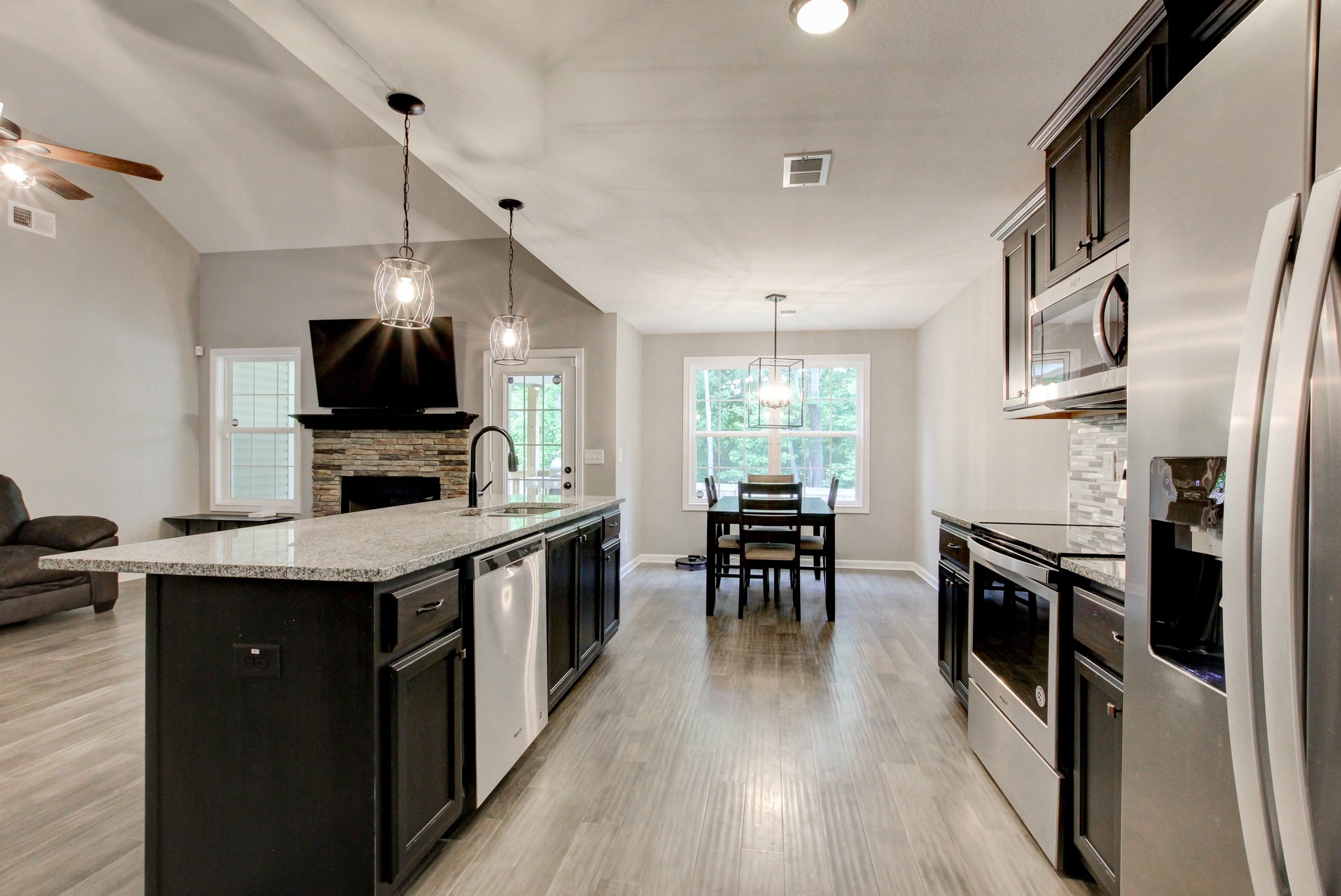 825 Rushing Drive Clarksville, TN 37042 - Photo 35 of 70 a kitchen with stainless steel appliances a stove top oven a sink dishwasher a dining table and chairs with wooden floor