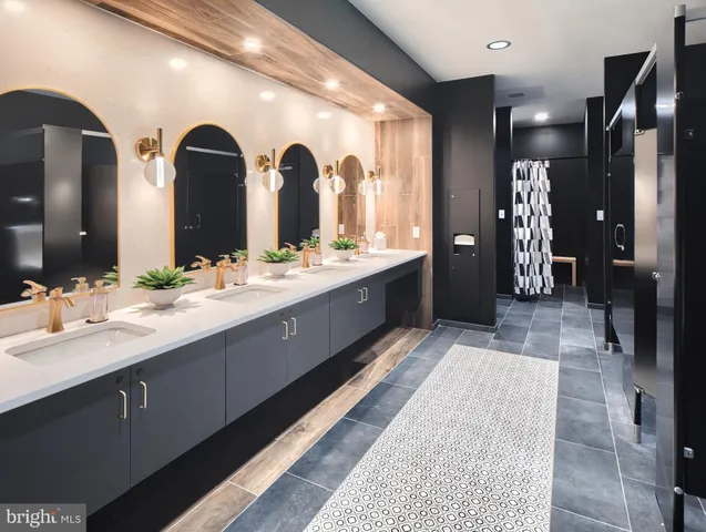 a bathroom with double vanity sinks a large mirror and shower