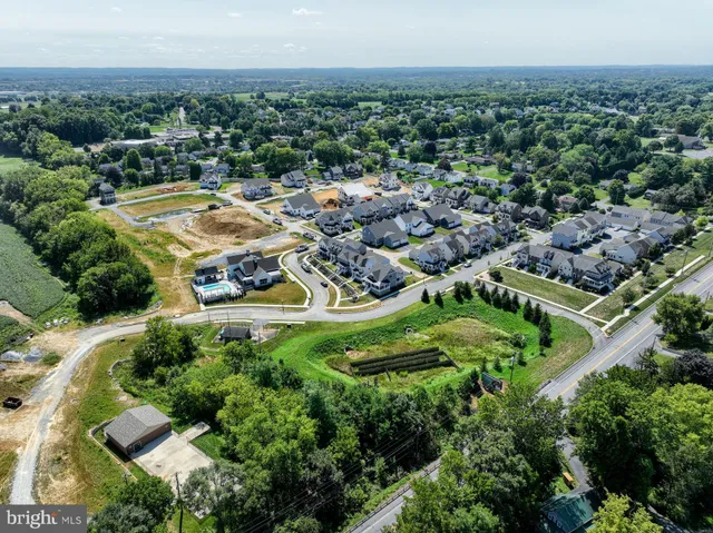 an aerial view of residential houses with outdoor space and trees
