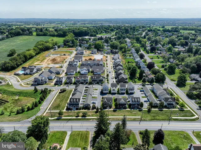 an aerial view of a city with lots of residential buildings and mountain view in back