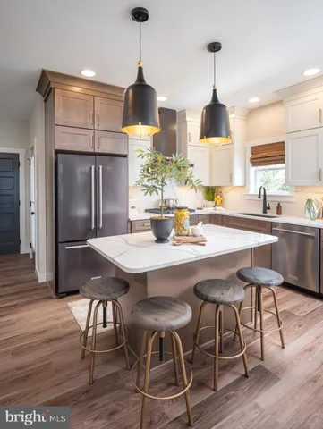 a kitchen with stainless steel appliances a dining table chairs and wooden floor