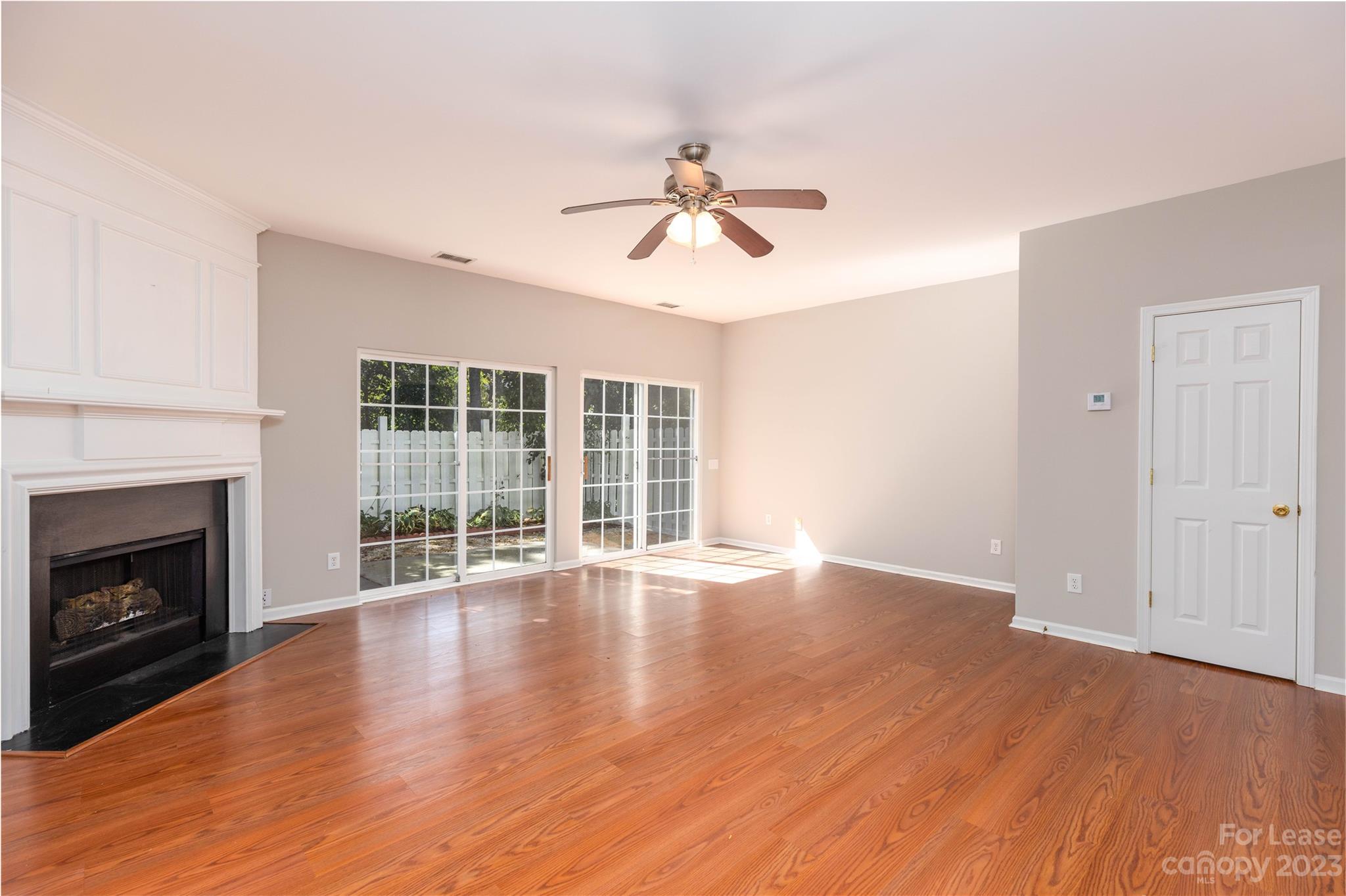 6879 Rothchild Drive Charlotte, NC 28270 - Photo 7 of 19 a view of empty room with wooden floor and fireplace